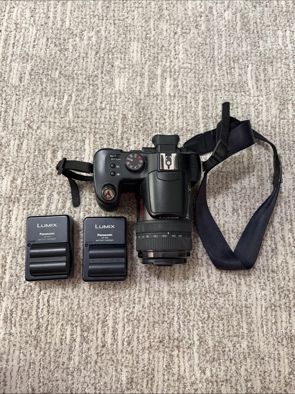 Panasonic Black Lumix DSLR with Attached Lens and Dual Chargers